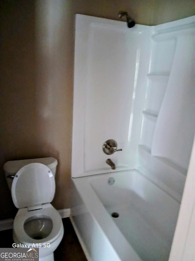 bathroom featuring tub / shower combination and toilet