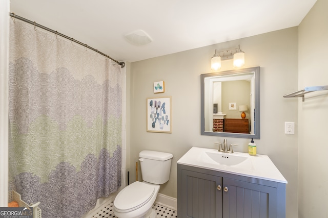 bathroom featuring walk in shower, vanity, tile patterned flooring, and toilet