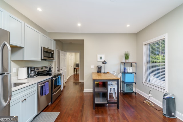 kitchen featuring appliances with stainless steel finishes, white cabinetry, and dark hardwood / wood-style floors