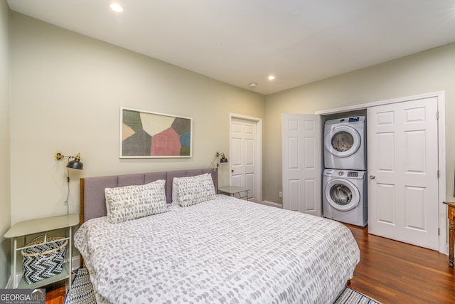 bedroom featuring dark wood-type flooring and stacked washing maching and dryer