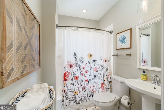 bathroom featuring a shower with curtain, sink, and toilet