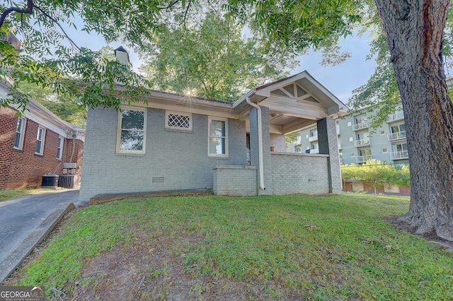 view of front of house featuring a front yard and central AC unit