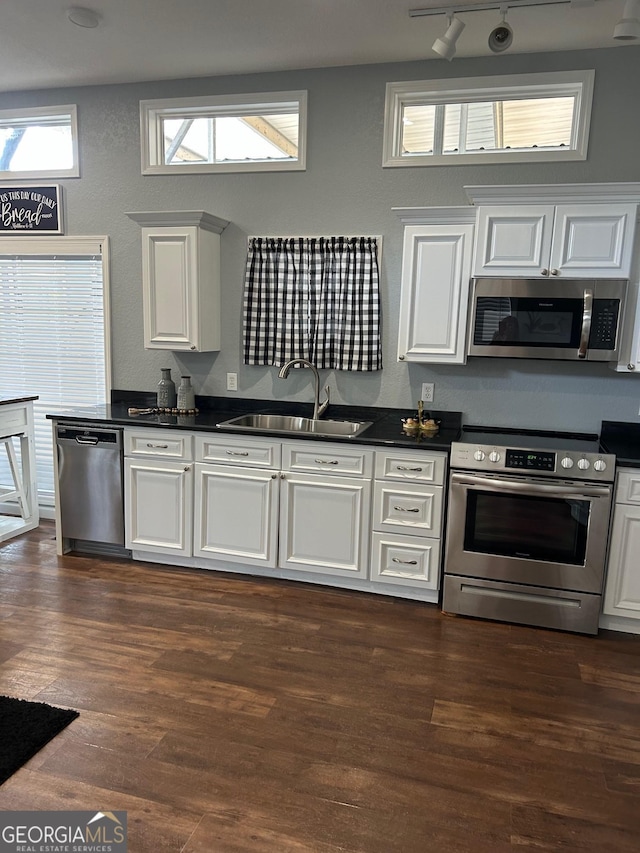 kitchen with track lighting, a healthy amount of sunlight, sink, and stainless steel appliances