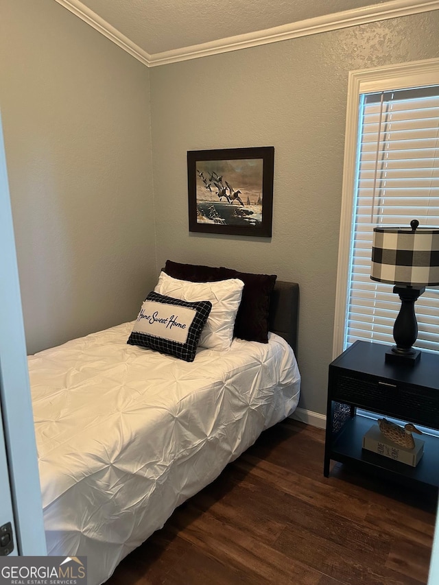 bedroom featuring crown molding and dark wood-type flooring