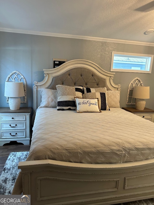 bedroom featuring ornamental molding and dark hardwood / wood-style flooring