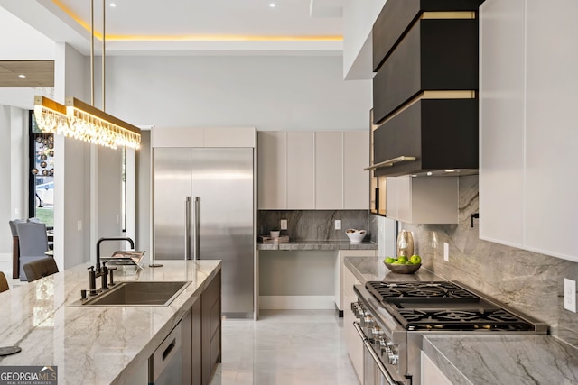 kitchen featuring tasteful backsplash, appliances with stainless steel finishes, sink, gray cabinets, and light stone counters