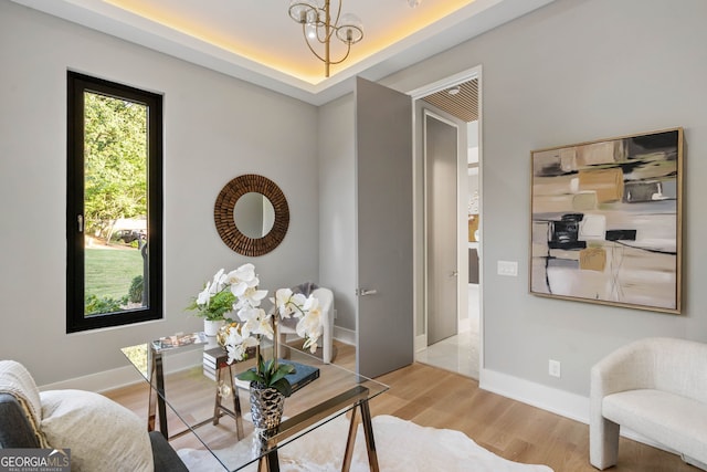 living area featuring a notable chandelier and light wood-type flooring