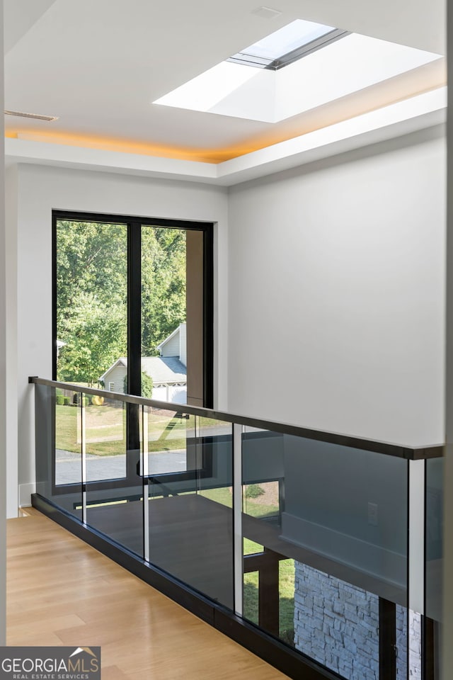 entryway with hardwood / wood-style floors and a skylight