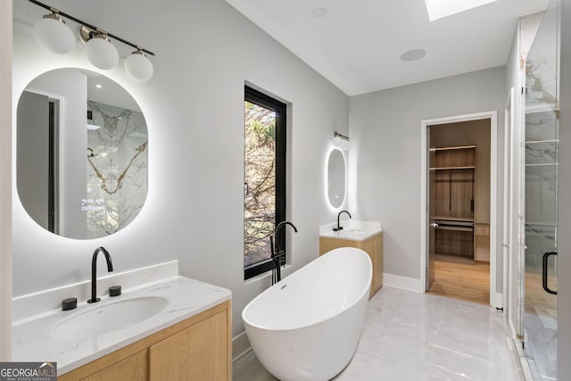 bathroom featuring vanity, shower with separate bathtub, and a skylight