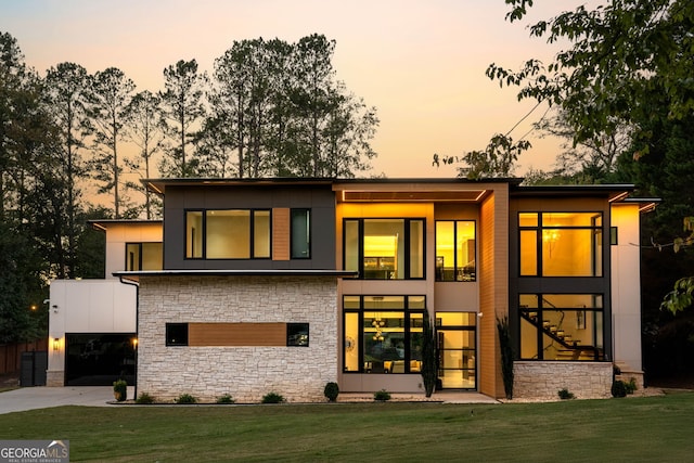 back house at dusk featuring a yard