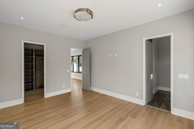 interior space with a spacious closet, a closet, and light hardwood / wood-style flooring