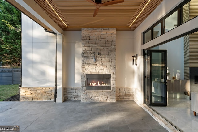 view of patio / terrace with ceiling fan and an outdoor stone fireplace