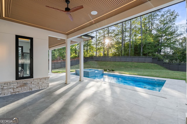 view of pool with a patio, ceiling fan, a lawn, and an in ground hot tub