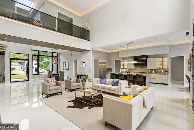 living room featuring a skylight and a high ceiling