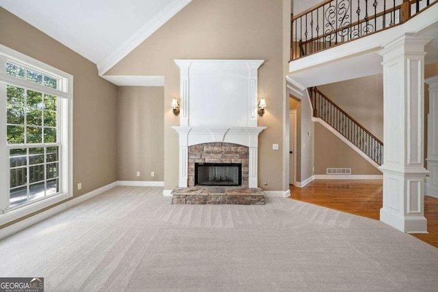 unfurnished living room featuring a fireplace, light hardwood / wood-style floors, high vaulted ceiling, and crown molding