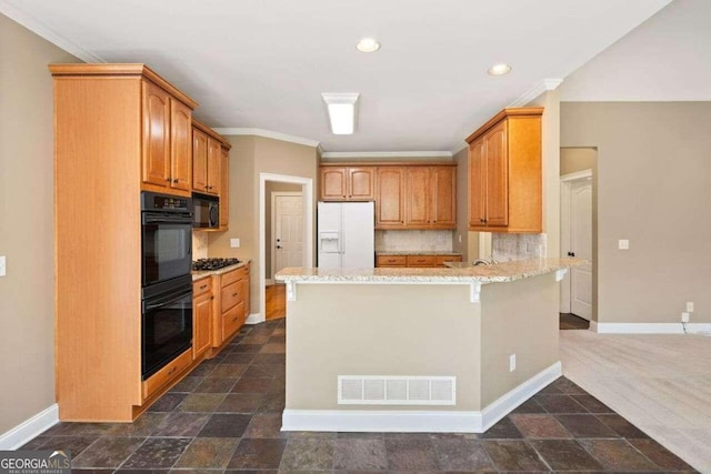 kitchen with light stone counters, black appliances, kitchen peninsula, a kitchen bar, and backsplash