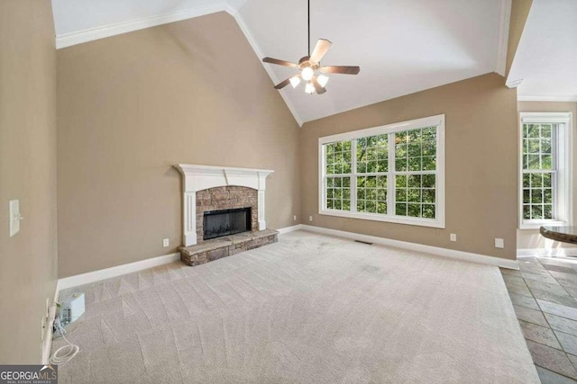 unfurnished living room with a stone fireplace, crown molding, a wealth of natural light, and ceiling fan