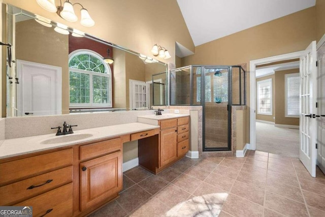 full bathroom with vaulted ceiling, a healthy amount of sunlight, a sink, and double vanity