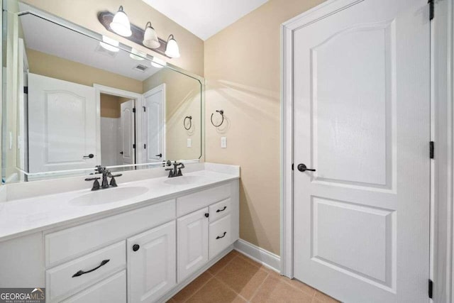 full bath with visible vents, baseboards, a sink, and double vanity