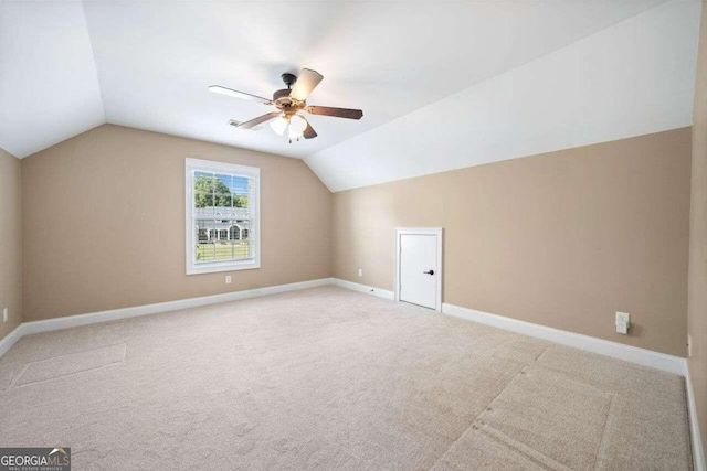 bonus room with light carpet, vaulted ceiling, baseboards, and ceiling fan