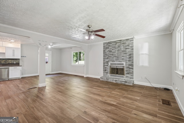 unfurnished living room with crown molding, a textured ceiling, hardwood / wood-style flooring, and ceiling fan