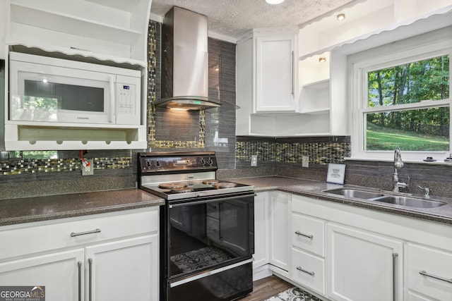 kitchen featuring black range with electric cooktop, sink, white cabinetry, and wall chimney range hood