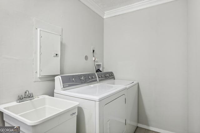 washroom featuring ornamental molding, sink, electric panel, washing machine and dryer, and a textured ceiling