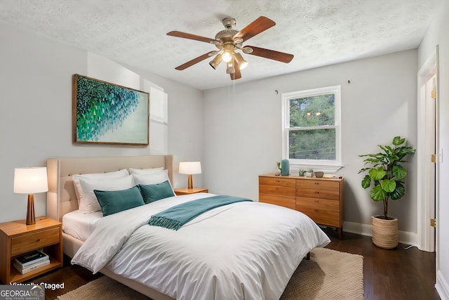 bedroom with dark wood-type flooring, a textured ceiling, and ceiling fan