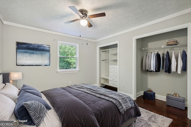 bedroom with ceiling fan, crown molding, a textured ceiling, and dark hardwood / wood-style flooring