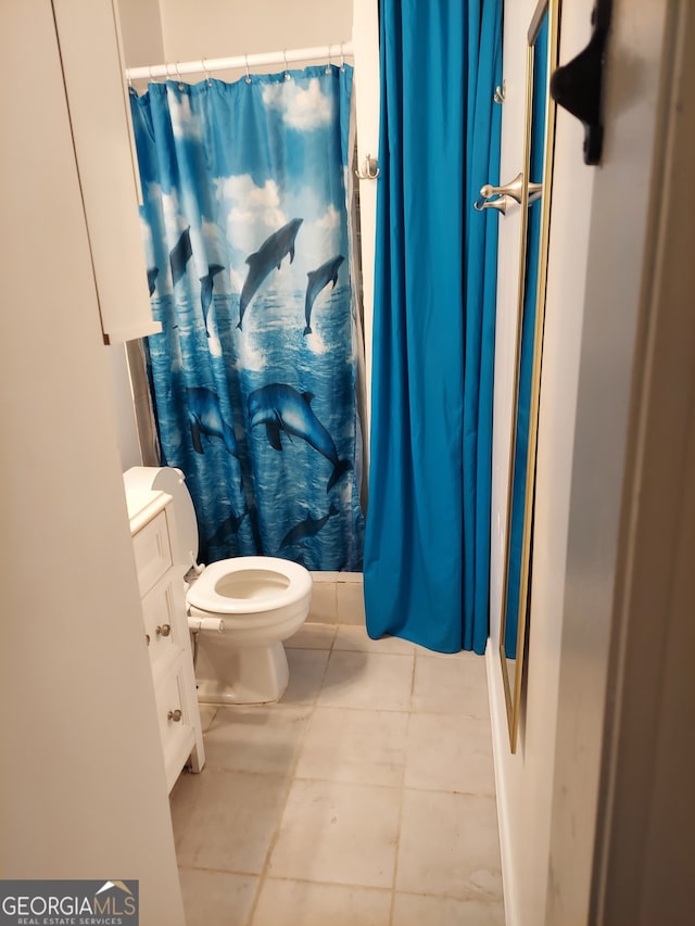 bathroom featuring toilet, vanity, tile patterned floors, and a shower with shower curtain