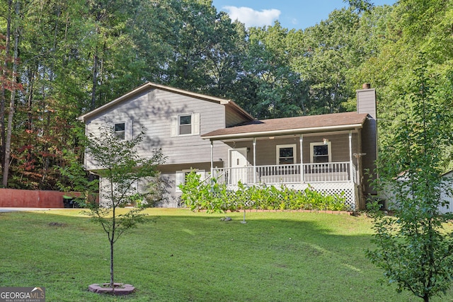 tri-level home featuring covered porch and a front yard