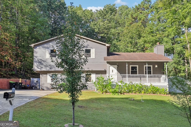 split level home featuring covered porch and a front lawn