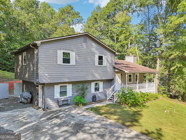 tri-level home featuring a porch and a front lawn