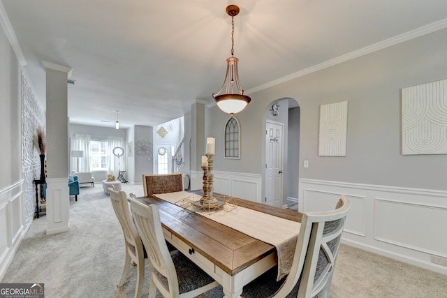 dining room with crown molding and light colored carpet