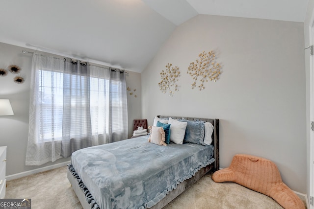 carpeted bedroom featuring vaulted ceiling and multiple windows