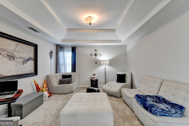 carpeted living room with a raised ceiling