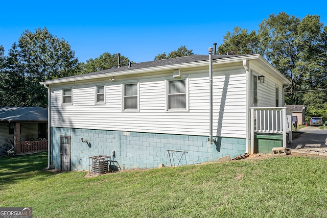 view of side of property with a yard and central air condition unit