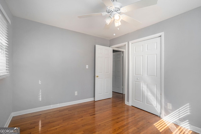 unfurnished bedroom featuring ceiling fan, a closet, and wood-type flooring