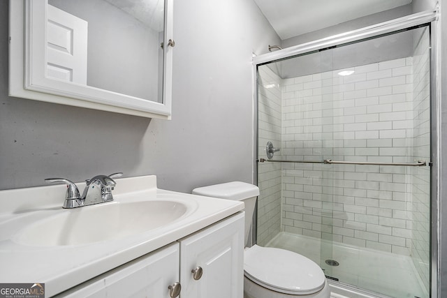 bathroom featuring vanity, toilet, and a shower with shower door