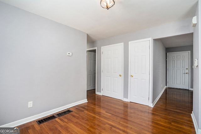 unfurnished bedroom with dark hardwood / wood-style flooring