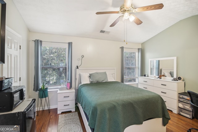 bedroom featuring ceiling fan, lofted ceiling, and dark hardwood / wood-style flooring