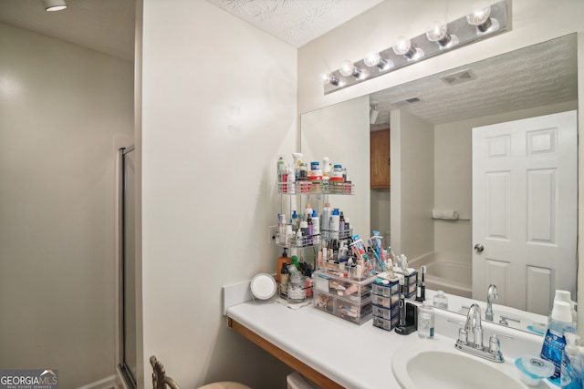 bathroom with vanity, plus walk in shower, and a textured ceiling