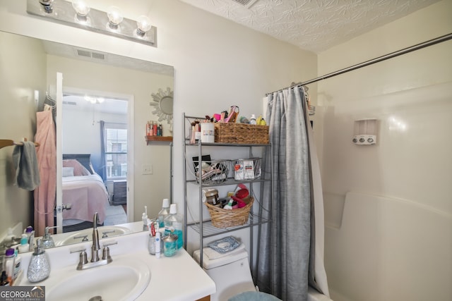 bathroom featuring vanity, a textured ceiling, and shower / tub combo