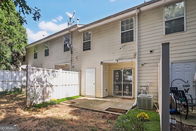 back of property with central air condition unit and a patio