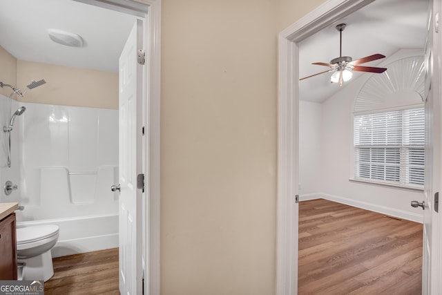 full bathroom with vaulted ceiling, ceiling fan, shower / tub combination, hardwood / wood-style flooring, and toilet