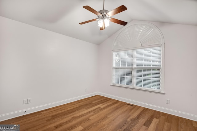 spare room with wood-type flooring, vaulted ceiling, and ceiling fan