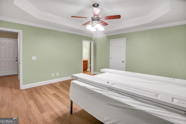 bedroom with a raised ceiling, ceiling fan, crown molding, and light hardwood / wood-style flooring