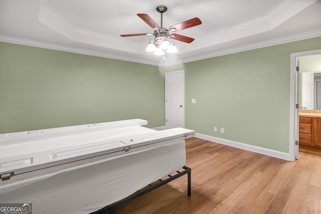 bedroom with a tray ceiling, ceiling fan, light hardwood / wood-style flooring, and ornamental molding