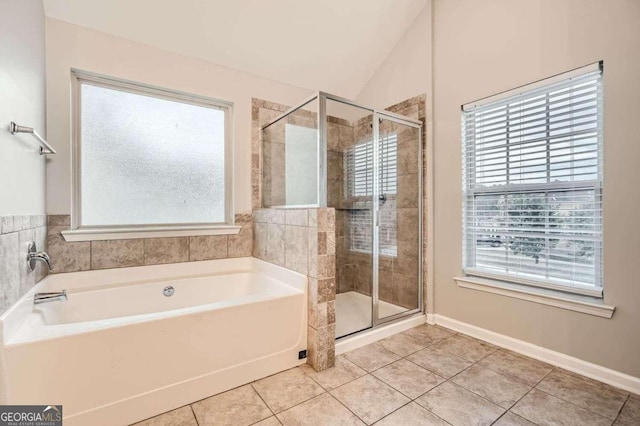 bathroom featuring lofted ceiling, tile patterned floors, and a healthy amount of sunlight