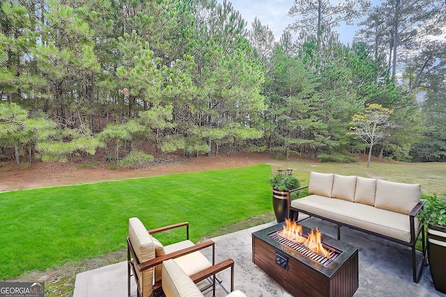 view of patio with an outdoor living space with a fire pit